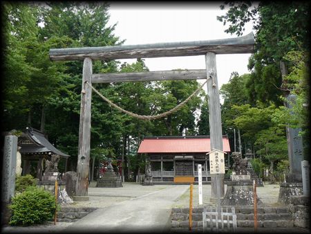 白鳥神社境内正面に設けられた木製鳥居と石造社号標と石造狛犬
