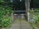 神明神社の境内を支える石垣から垣間見える拝殿と石燈籠